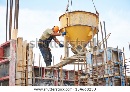 building workers at construction site doing concrete works with barrel