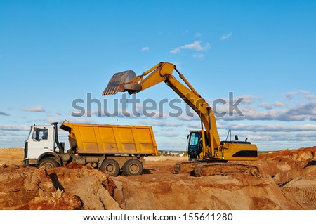 loader excavator machine loading dumper truck at sand quarry