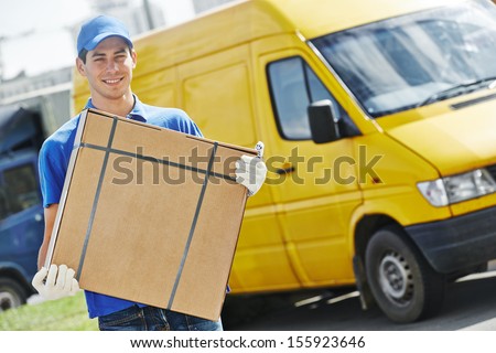 Smiling Young Male Postal Delivery Courier Man In Front Of Cargo Van Delivering Package