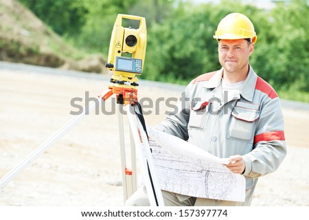One surveyor worker working with theodolite transit equipment at road construction site outdoors