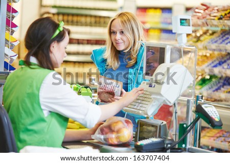 Customer Buying Food At Supermarket And Making Check Out With Cashdesk Worker In Store