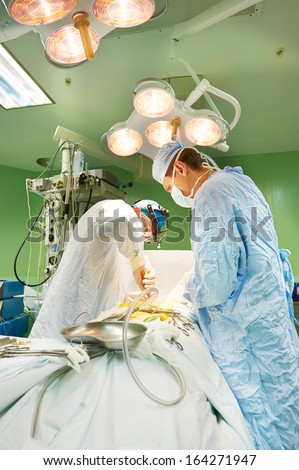 surgeon in uniform perform operation on a patient at cardiac surgery clinic