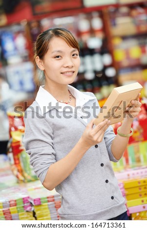 chinese young woman choosing food tea during shopping at china supermarket
