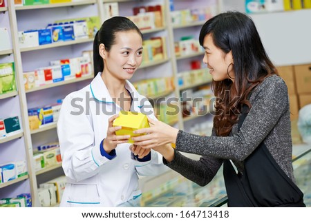 Two cheerful chinese pharmacist chemist woman standing in china pharmacy drugstore