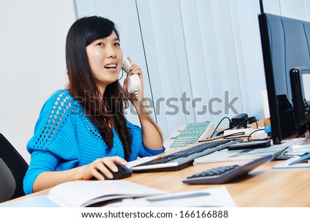 chinese office manager woman speaking on phone at work place