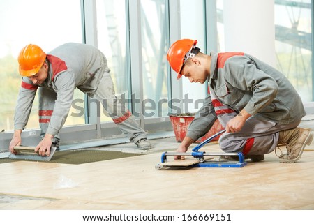 Two Industrial Tiler Builder Worker Installing Floor Tile At Repair Renovation Work