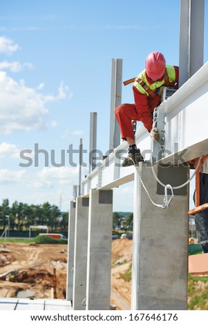 worker joiner in uniform and safety protective equipment at metal construction frames installation and assemblage