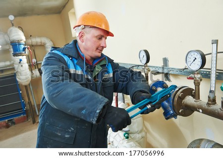 repairman engineer of fire engineering system or heating system open the valve equipment in a boiler house