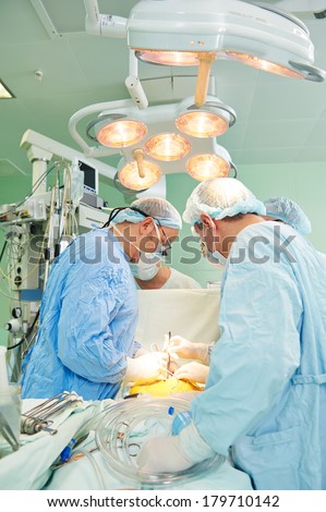 Team of surgeon in uniform perform heart transplantation operation on a patient at cardiac surgery clinic