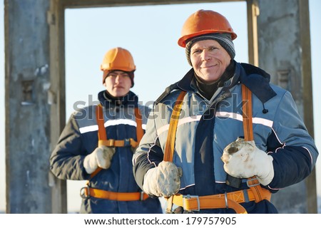 Team of builder worker in safety protective equipment at winter construction site