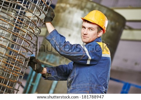 industrial worker making metal reinforcement carcass for concrete tube pipe