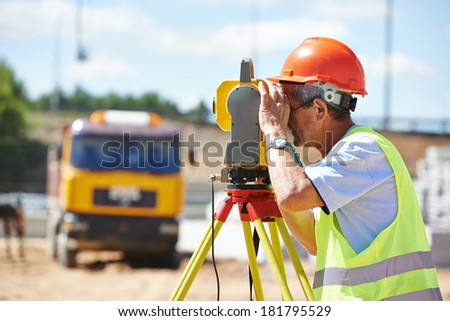 Portrait of builder worker with theodolite transit equipment at construction site outdoors during surveyor work