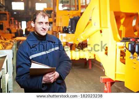 Portrait of young adult experienced industrial engineer over heavy industry machinery production line manufacturing workshop