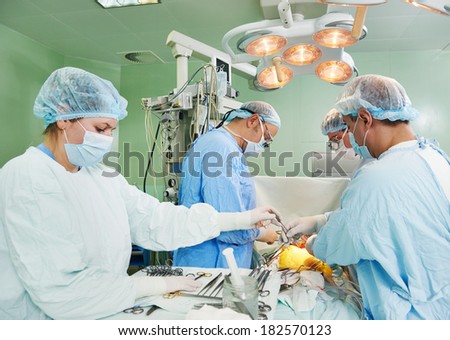 Team of surgeon in uniform perform heart transplantation operation on a patient at cardiac surgery clinic