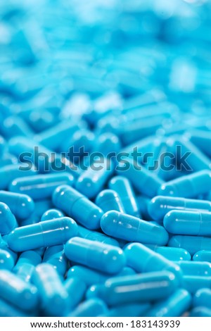 Pharmaceutical theme. Heap of blue capsule pills with medicine antibiotic. Shallow DOF