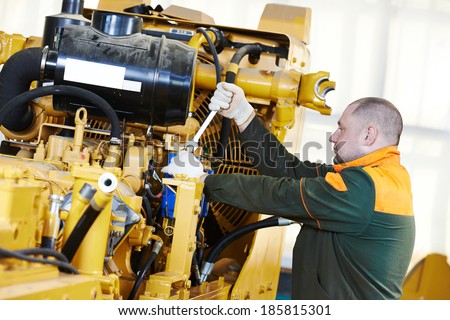 industrial worker during heavy industry machinery assembling on production line manufacturing workshop at factory
