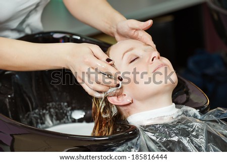 Highlight. Washing woman client hair in beauty parlour hairdressing salon