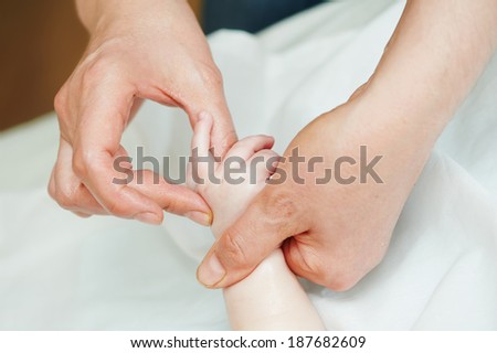 Masseur making a massage to child hand and finger