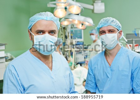 happy surgeons in uniform perform heart transplantation operation on a patient at cardiac surgery clinic