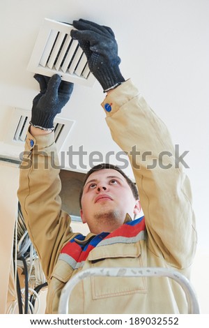 industrial builder installing ventilation or air conditioning filter holder in ceiling