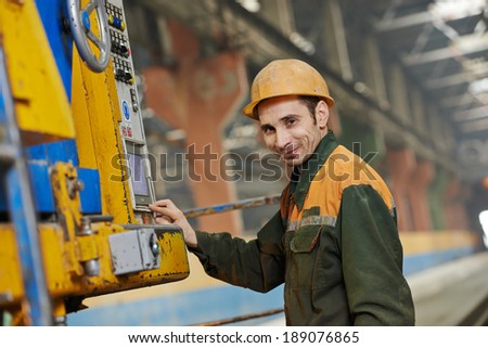 industrial worker operating concrete machine at factory workshop