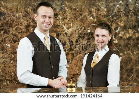 Receptionist or concierge workers standing at hotel counter