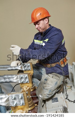 Electrician lineman repairman worker at huge power industrial transformer installation work