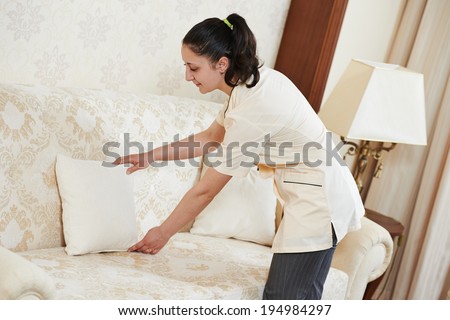 Hotel service. female housekeeping worker maid making order at inn room