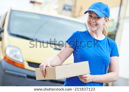 Smiling female postal delivery courier woman outdoors  in front of cargo van delivering package