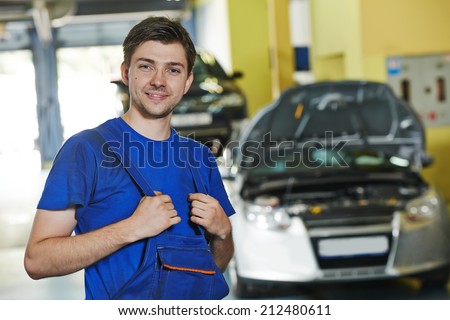 repairman auto mechanic portrait in car auto repair or maintenance shop service station