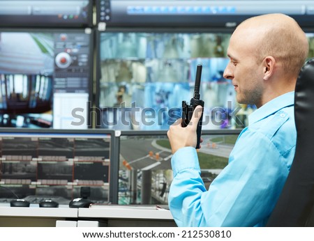 security guard watching video monitoring surveillance security system with portable radio transmitter