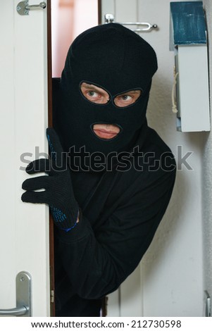 Thief burglar opening door during house breaking penetration