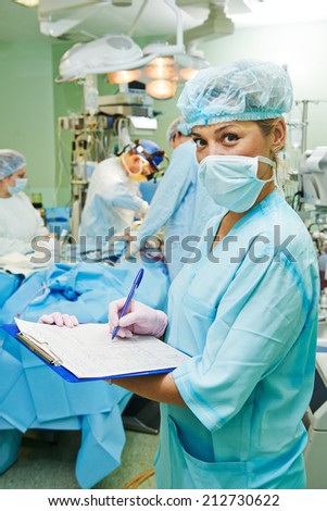 Portrait of surgeon nurse or doctor in uniform during cardiological operation on a patient at cardiac surgery clinic
