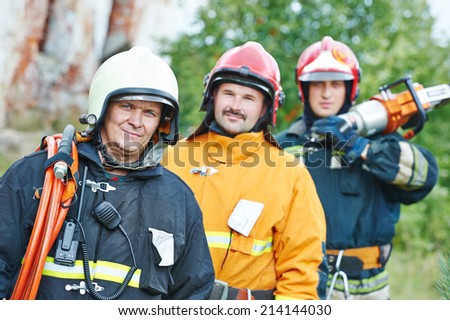 firefighter crew in uniform in front of fire engine machine and fireman team