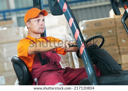 warehouse worker driver in uniform operating forklift stacker loader