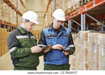 workers in warehouse with bar code scanner and tablet computer