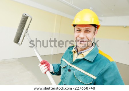 male plasterer portrait during floor covering works with self-levelling cement mortar