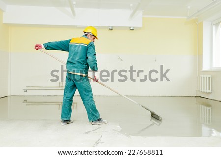 plasterer during floor covering works with self-levelling cement mortar