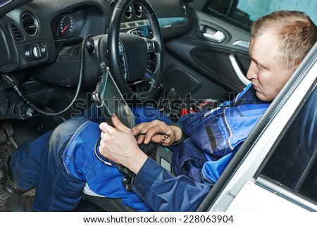 automobile computer diagnosis auto repairman industry mechanic worker servicing car auto in repair or maintenance shop service station