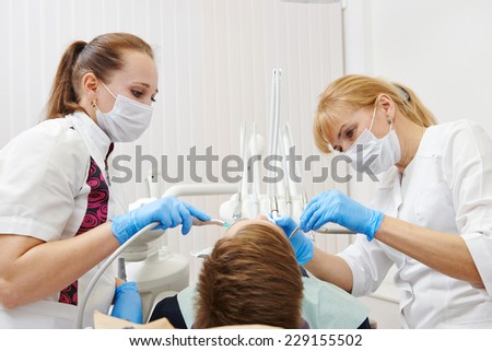 dentist orthodontist female doctor making dental care to patient at working place in clinic