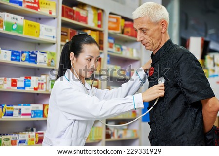 chinese pharmacist chemist woman examining heartbeat of customer in china pharmacy drugstore