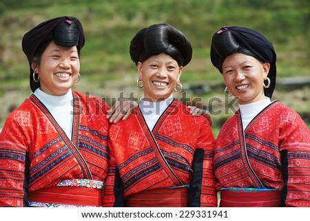 Group of happy chinese minority woman Yao in traditional dresses outdoors