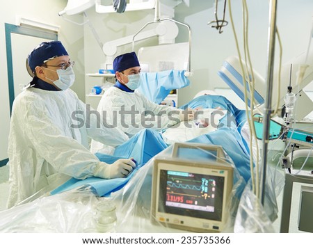 Team of vascular surgeon in uniform perform operation on a patient at cardiac surgery clinic