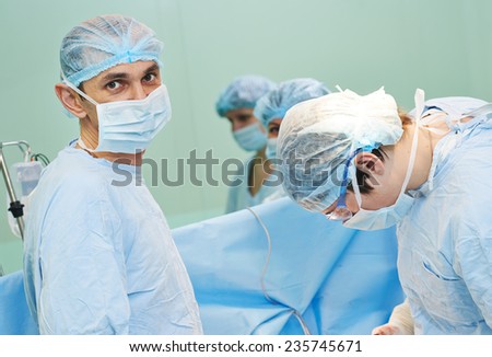 surgeons in uniform perform heart operation on a patient at cardiac surgery clinic