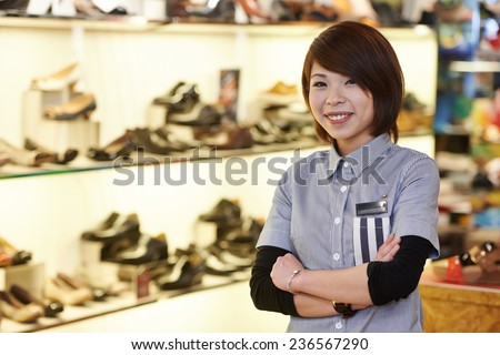 chinese young smiling female assistant seller in the shoe shop