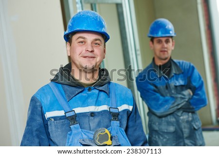 cheerful plasterboard workers team at a indoors wall insulation works
