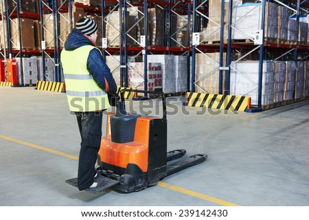 Electric forklift pallet stacker truck equipment at work in warehouse