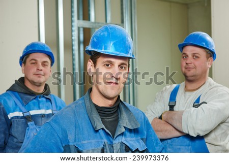 cheerful plasterboard workers team at a indoors wall insulation works