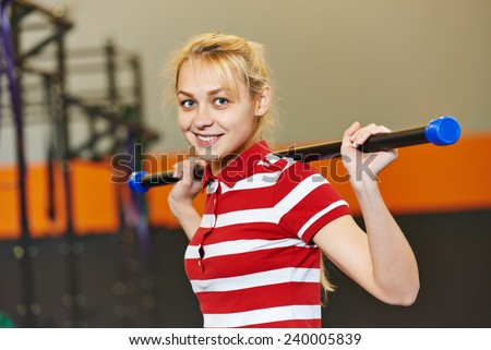 Young woman training exercises with training stick in fitness club gym