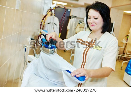 cleaning services. Woman with iron working at ironing shop